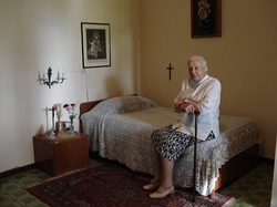 Sorella Elvira seduta sul letto in cui è morto Mons. Luigi Novarese
